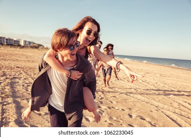 Image de jeunes couples heureux et amoureux amis marchant dehors sur la plage s'amusant. : photo de stock