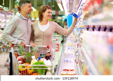 Image of happy couple with cart choosing products in supermarket - Powered by Shutterstock