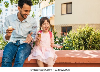 Image of happy cute little girl sitting with dad on the city street and eating ice-cream outdoor. Fun girl kid and father have fun and playing outside. Good relationship between dad and daughter - Powered by Shutterstock