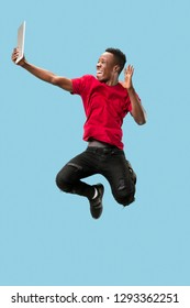 Image Of Happy Excited Young African Man Jumping Isolated Over Yellow Background Using Laptop Computer.