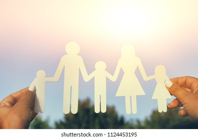 image of happy family concept.woman holding paper cut people against sky during sunset - Shutterstock ID 1124453195