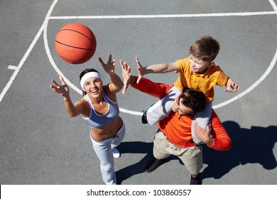 Image Of Happy Female Throwing Ball With Man And Kid Near By