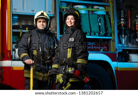 Image of happy fireman and woman near fire truck