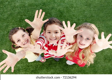 Image Of Happy Friends On The Grass Raising Arms