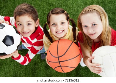 Image of happy friends on the grass with balls looking at camera