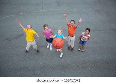 Image of happy friends playing basketball on sports ground