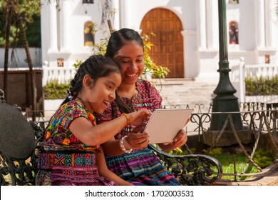 Image Of Happy Indigenous Girls In A Park Using A Tablet.