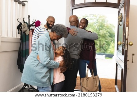 Image of happy multi generation african american family entering house and welcoming each other. Extended family, spending quality time together concept.