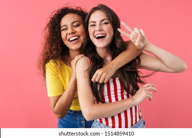 Image Of Happy Multinational Girls Hugging And Showing Peace Sign Isolated Over Pink Background