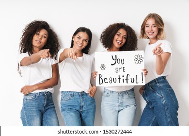 Image of a happy optimistic pleased young women multiracial friends posing isolated over white wall background holding blank with compliments text.
