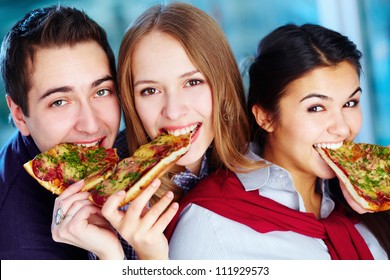 Image Of Happy Teenage Friends Eating Pizza And Looking At Camera