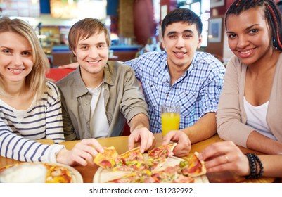Imagen de amigos adolescentes felices comiendo pizza en el café