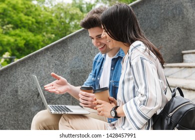 Image Of Happy Young Amazing Loving Couple Business People Colleagues Outdoors Outside On Steps Using Laptop Computer Drinking Coffee.