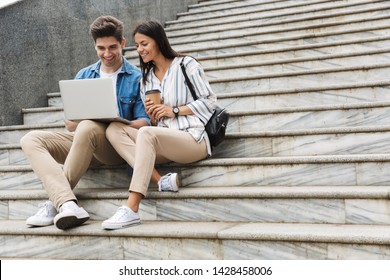 Image Of Happy Young Amazing Loving Couple Business People Colleagues Outdoors Outside On Steps Using Laptop Computer Drinking Coffee.