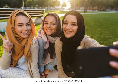 Image Of A Happy Young Arabian Women Students Take Selfie By Phone In Park Outdoors.