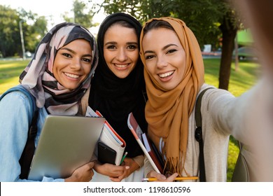 Image Of A Happy Young Arabian Women Students Holding Books In Park Outdoors Take Selfie By Camera.