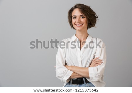Photo of Image of happy young business woman posing isolated over grey wall background.
