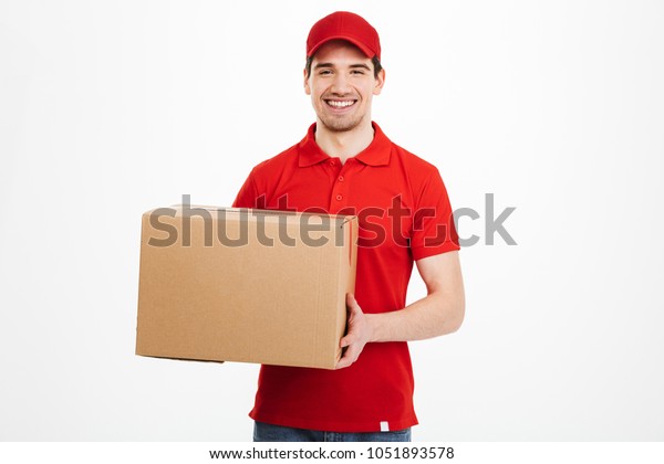 白い背景に小包の郵便箱を持つ赤い帽子の幸せな若い配達人の画像 の写真素材 今すぐ編集