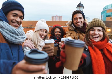 Image of a happy young friends talking with each other drinking coffee outdoors winter concept. Foto Stock