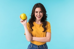 Image Of Happy Young Pretty Woman Posing Isolated Over Blue Wall Background Holding Apple.