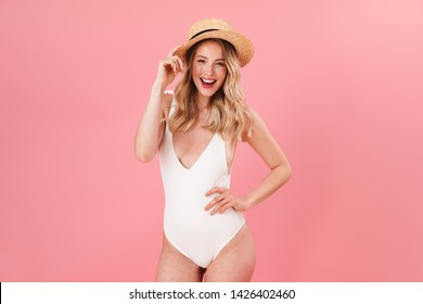 Image of happy young woman posing isolated over pink wall background dressed in swimwear.