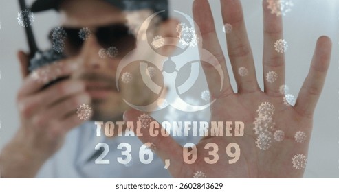 Image of a hazard sign with total confirmed number rising with cells floating over caucasian man. coronavirus covid-19 pandemic concept digital composition