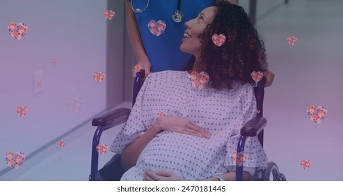 Image of heart icons over happy biracial pregnant woman talking with nurse. maternal mental health awareness week concept digitally generated image. - Powered by Shutterstock