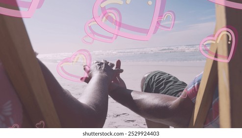 Image of hearts over senior african american couple lying on sunbeds on sunny beach. healthy and active retirement beach holiday concept digitally generated image. - Powered by Shutterstock