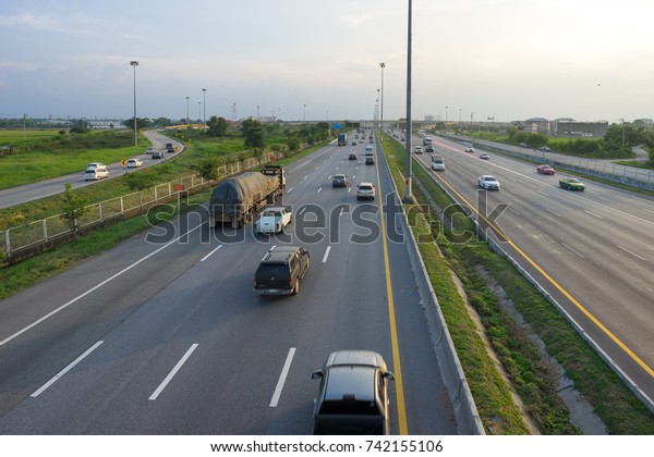 Image of a highway with busy traffic in the\
evening in Thailand.