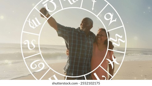 Image of horoscope over happy senior biracial couple walking at beach. Lifestyle, nature, horoscope and symbols concept digitally generated image. - Powered by Shutterstock