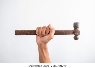 Image of a human hand holding a hammer with a wooden handle. Portrays themes of labor, tools, and craftsmanship. Captures the essence of manual work and vintage tools.