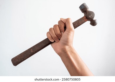 Image of a human hand holding a hammer with a wooden handle. Portrays themes of labor, tools, and craftsmanship. Captures the essence of manual work and vintage tools.