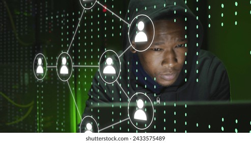 Image of icons and data processing over african american male hacker using laptop. Global digital interface, cloud computing and data processing concept digitally generated image.