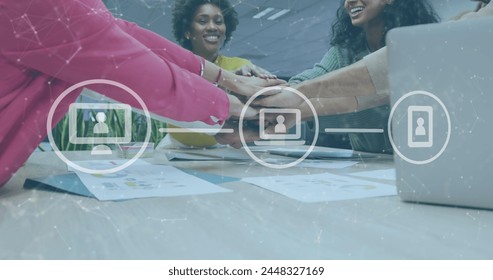 Image of icons and data processing over diverse business people stacking hands in office. Global business, finances, computing and data processing concept digitally generated image.