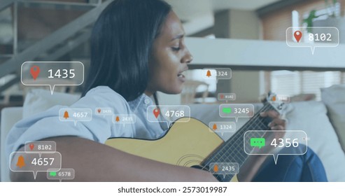 Image of icons and data processing over biracial woman playing guitar. Leisure, social media, connections, computing and data processing concept digitally generated image.