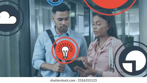 Image of icons over diverse coworkers discussing reports on digital tablet in office. Digital composite, multiple exposure, ideas, globalization, business, planning, teamwork and technology. - Powered by Shutterstock