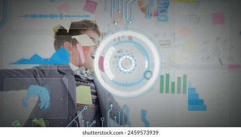 Image of infographic interface over caucasian boy with sticky notes on face rotating in office. Digital composite, graph, radar, business, imitation, childhood, enjoyment, carefree, globalization.