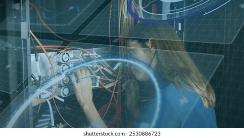 Image of interface with data processing over caucasian female engineer working at server room. Computer interface and business data storage technology concept