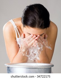 Image of isolated woman washing her face from wash-basin
