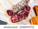 Image of italian piacenza salami cut in slices on a wooden surface, close-up