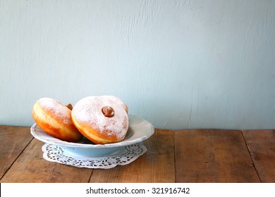 image of jewish holiday Hanukkah with donuts on wooden table 