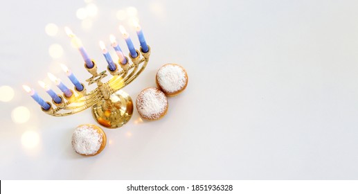 Bild des jüdischen Urlaubs Hanukka mit Menorah (traditionelles Candelabra), Donut und Holzdreidel (Draufsicht)