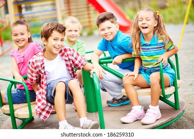 Image of joyful friends having fun on carousel outdoors  - Shutterstock ID 186259310