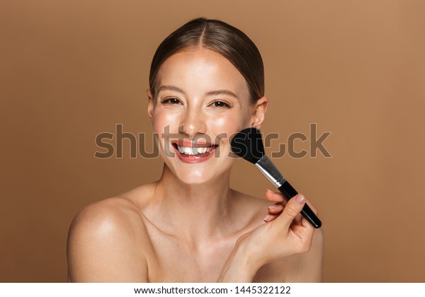 Image Of Joyful Half Naked Woman Smiling At Camera And Using Makeup Brush Isolated Over Beige