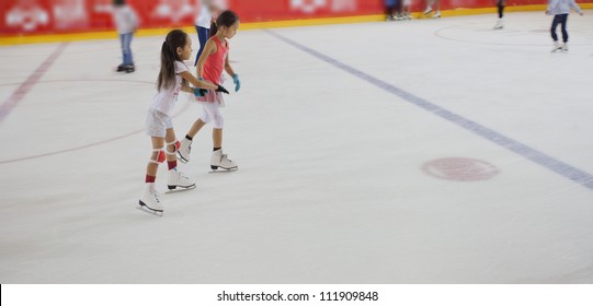 Image Of Kids Who Are Ice Skating In The Ice Rink Indoors.