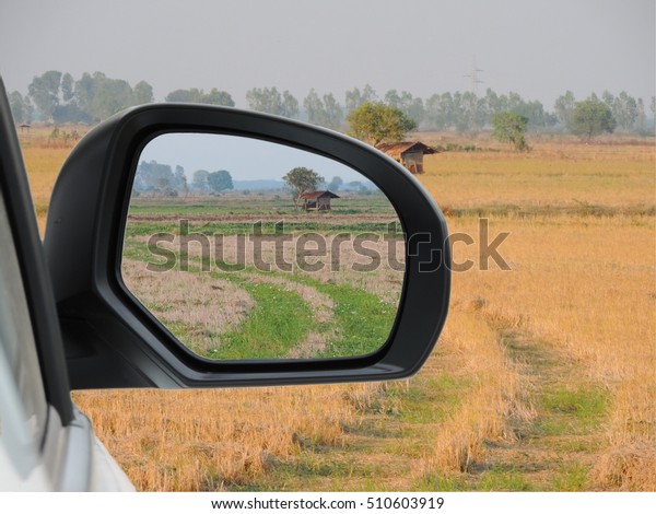 Image of landscape with car mirror,concept past and\
present.          