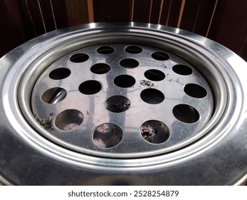 image of a large ashtray, small circle motif for disposing of cigarette ash

