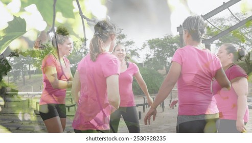 Image of leaves over diverse women at obstacle course high fiving. Global sport, health, fitness and digital interface concept digitally generated image. - Powered by Shutterstock