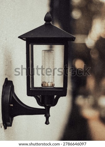 Image of an LED lamp with a black frame on a white painted wall.