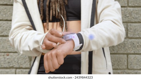 Image of light beam and lens flare over midsection of woman using smartwatch. everyday life, technology and positivity concept digitally generated image. - Powered by Shutterstock